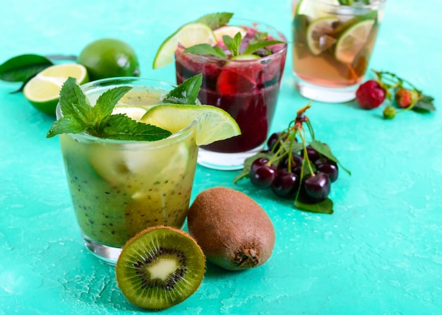 Bebidas frias de verão com frutas frescas, frutas e hortelã. Mojito de morango, smoothies de cereja, coquetel de kiwi em copos.