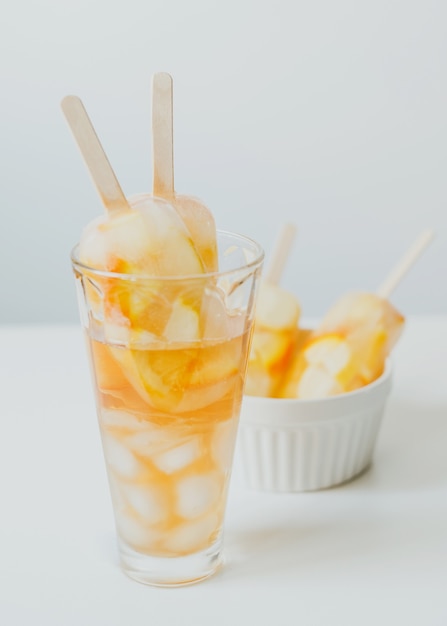 Bebidas frías de verano cóctel de cítricos naranja y limón con hielo y paletas en palo