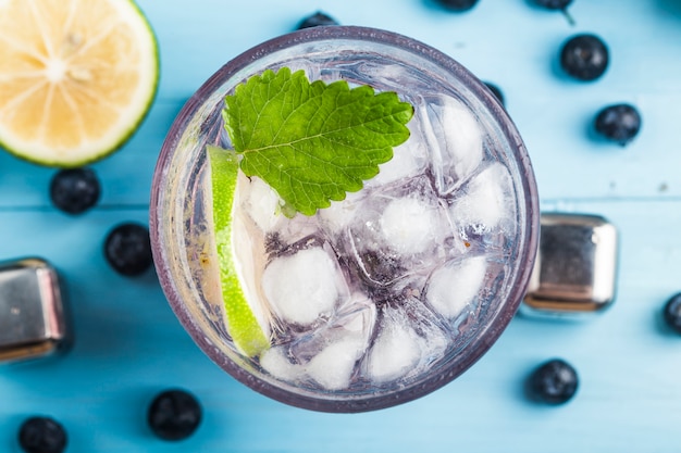 Bebidas refrescantes de verão, limonada de mirtilo ou coquetel de mojito com limão, mirtilos frescos e hortelã,