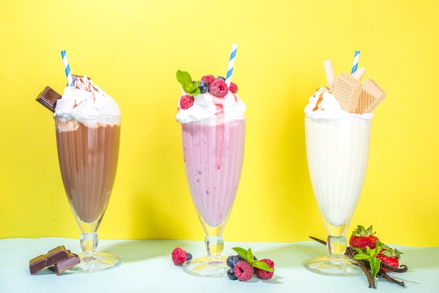 Bebidas refrescantes de verão, milkshakes, crazy shakes com sorvete, frutas vermelhas, baunilha, chocolate. Sobre um fundo amarelo azul brilhante