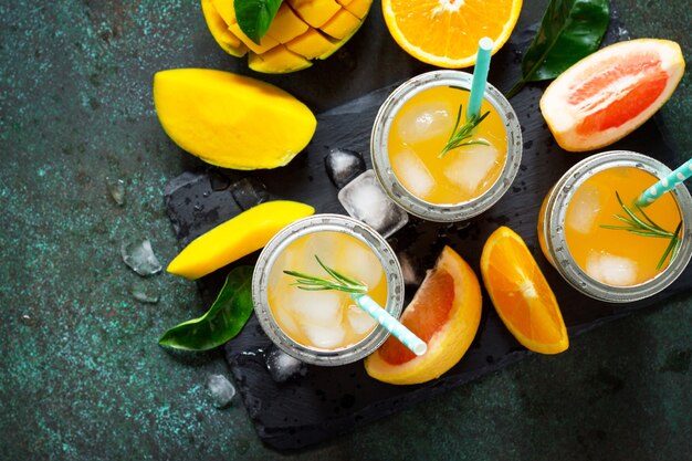 Bebidas refrescantes frescas de verano Bebidas multifrutas de cítricos y mango con hielo Espacio de copia