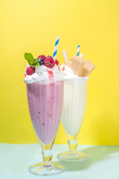 Bebidas refrescantes de verano, batidos, batidos locos con helado, frutos rojos, vainilla, chocolate. Sobre un fondo amarillo azul brillante