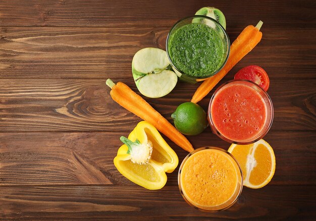 Bebidas saborosas de smoothie com legumes e frutas na mesa