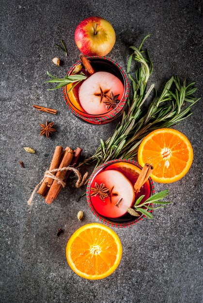 Bebidas tradicionales de invierno y otoño. Cócteles de Navidad y Acción de Gracias. Vino caliente con naranja, manzana, romero, canela y especias.