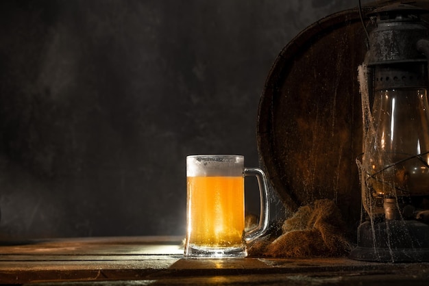 Becher mit frischem hellem Bier mit Schaum auf hölzernem Vintage-Hintergrund mit FassÑŽ Alter Weinkeller oder Pub