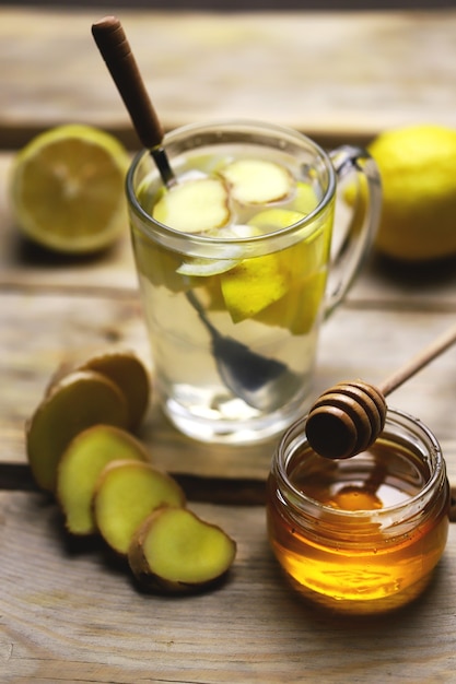 Becher mit Getränk aus Honig, Zitrone und Ingwer