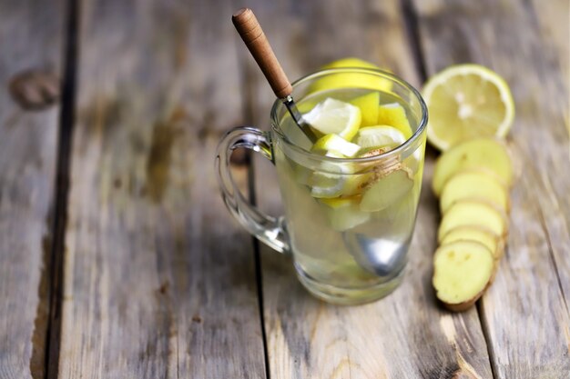 Becher mit Getränk aus Honig, Zitrone und Ingwer