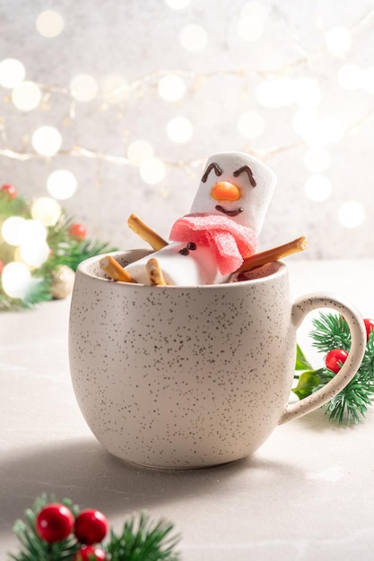 Becher mit heißer Schokolade mit geschmolzenem Marshmallow-Schneemann