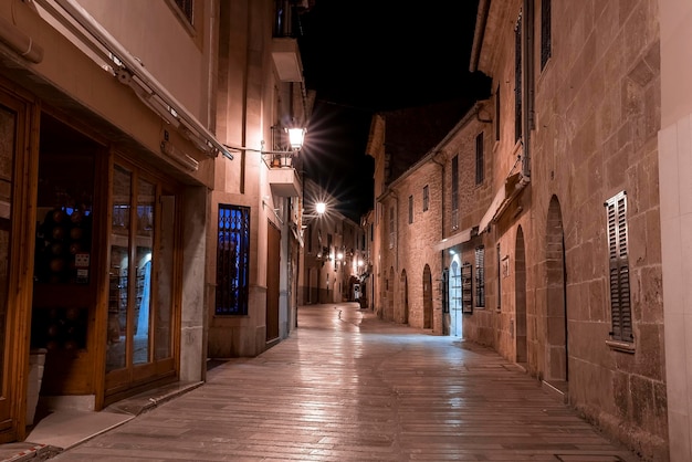 Beco iluminado entre edifícios residenciais na cidade velha à noite