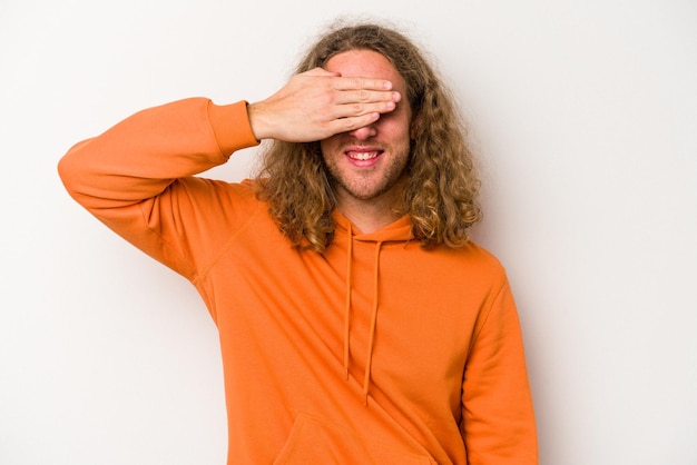 Foto bedeckt die augen mit den händen, lächelt breit und wartet auf eine überraschung