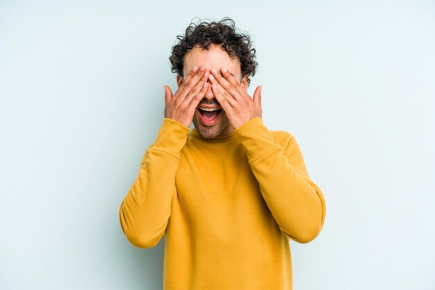 Bedeckt die Augen mit den Händen, lächelt breit und wartet auf eine Überraschung