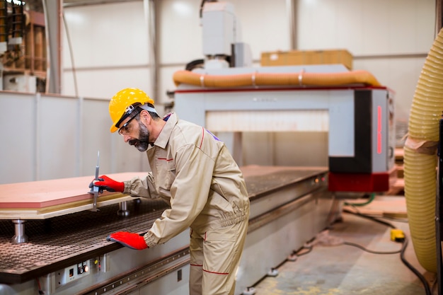 Bedienungsmaschineneinheiten des älteren Mannes in bereitstehendem Bedienfeld der modernen Fabrik