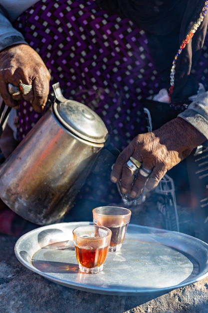 Beduinenfrau, die Tee auf dem Feuer im Beduinendorf, Ägypten kocht