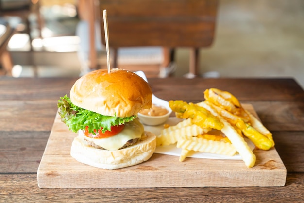 Beef Burger mit Käse und Kartoffelchips auf Holztablett