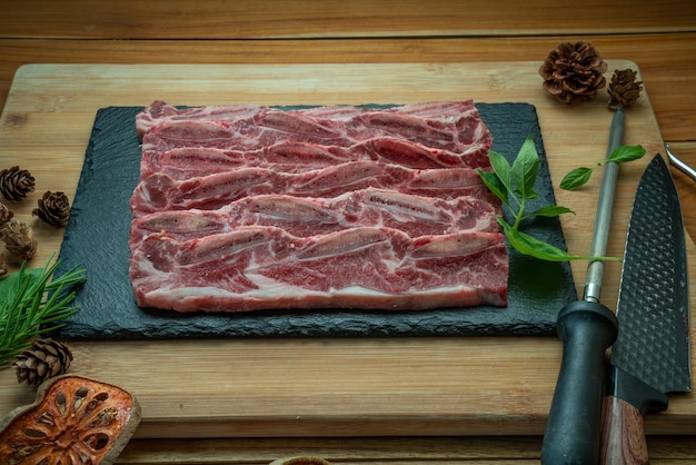 Beef Short Ribs Sliced Bonein auf HolzhintergrundCross Cut Short Ribs Beef auf schwarzem Teller