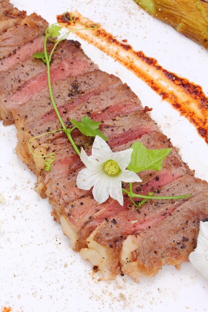 Beefsteak mit essbaren Blumen dekorieren