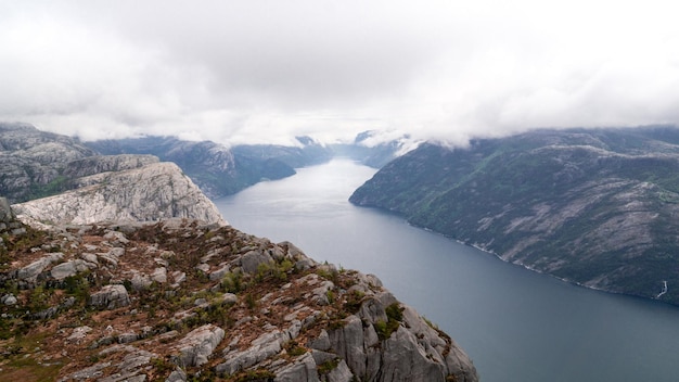 Beeindruckender Lysefjord zwischen hohen Bergen an einem bewölkten Tag vorbei am Preikestollen