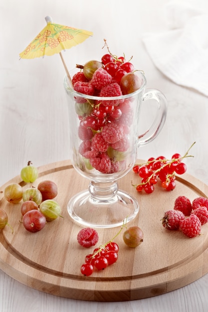 Beeren in einem Glas mit einem Regenschirm