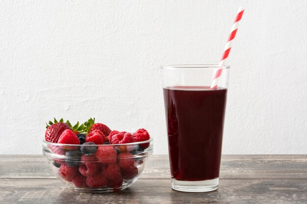 Beeren Smoothie auf Holztisch und weißem Hintergrund