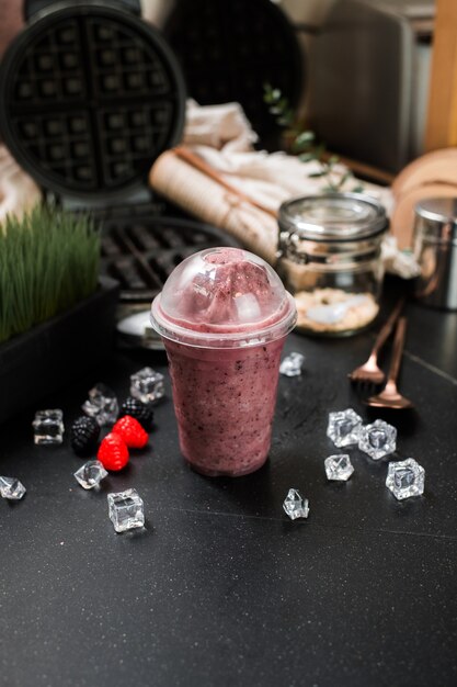 Beeren-Smoothie serviert auf schwarzem Tisch im cafeÃ¢Â€Â‹