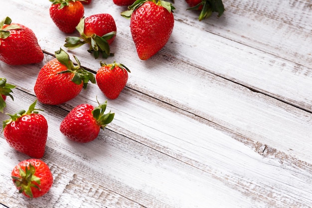 Beeren von Bio-Erdbeeren auf einem Kopierraum aus Holz