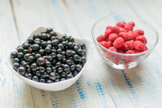 Beeren von Himbeeren und schwarzen Johannisbeeren Frische Sommerbeeren in Platten