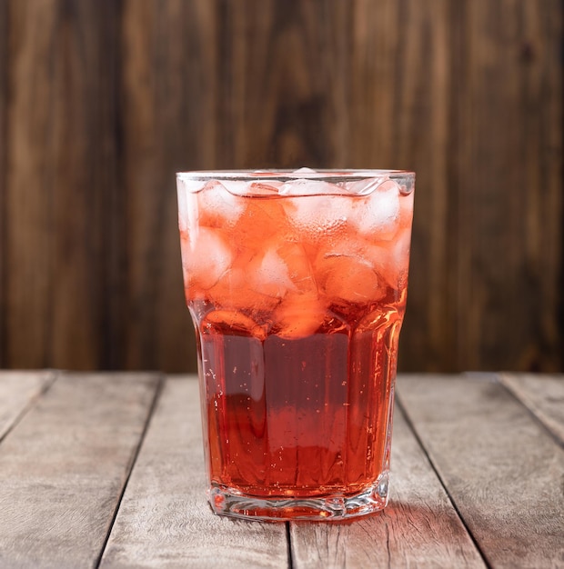 Beerensoda in einem Glas mit Eis über Holztisch