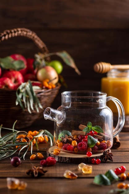 Beerentee Sanddorn und Himbeeren in einer Teekanne aus Glas mit eingegossenem Tee