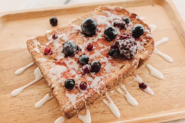 Beerentoastbrot mit Kondensmilch auf Holzplatte