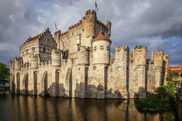 Befestigte Mauern und Türme der mittelalterlichen Burg Gravensteen mit Graben im Vordergrund Gent Ostflandern Belgien