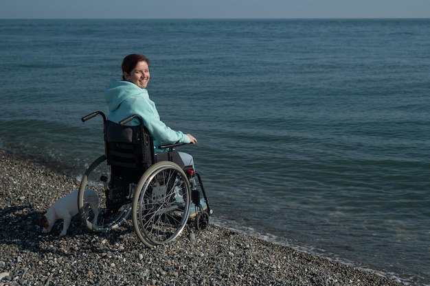 Befriedigte kaukasische Frau in einem Rollstuhl am Meer