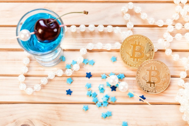 Beginn des Glücksspiels mit zwei goldenen Bitcoins und einem Cocktail "Blue Lagoon"