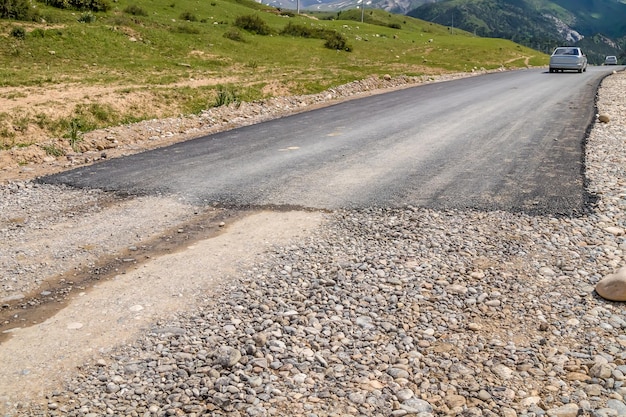 Beginn einer asphaltierten Straße in einem bergigen Gebiet