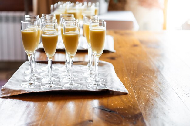 Foto behälter voller gläser zitronen- oder mango-sorbett mit cava bei einer veranstaltung während des cocktails