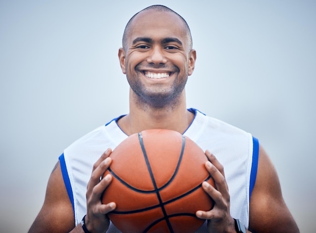 Behalten Sie das Preisfoto eines jungen männlichen Basketballspielers im Auge, der den Ball hält