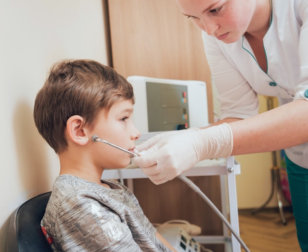 Behandlung und Aufwärmen der Ohren eines Jungen. Moderne Pädiatrie.
