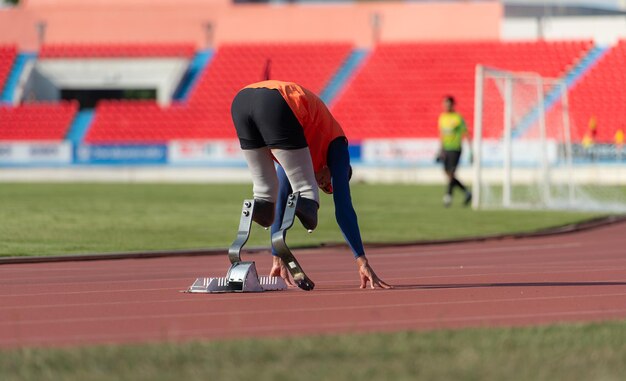 Foto behinderte athleten bereiten sich in startposition vor, um auf der stadionbahn zu laufen