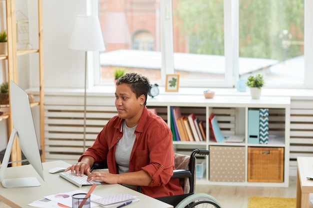 Behinderte Frau, die im Büro arbeitet