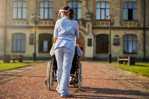 Foto behinderter älterer mann und assistent außerhalb des krankenhauses