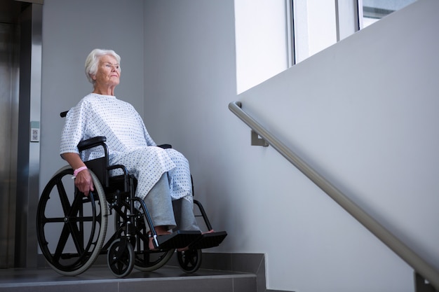 Behinderter älterer Patient im Rollstuhl nahe der Treppe