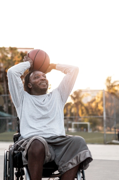 Foto behinderter mann im rollstuhl beim basketballspielen