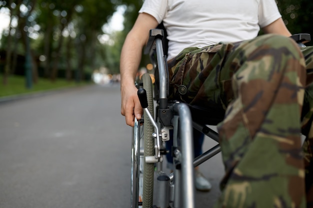 Foto behinderter soldat, blick auf die beine. gelähmte menschen und behinderung, handicap-überwindung. behinderter mann im park