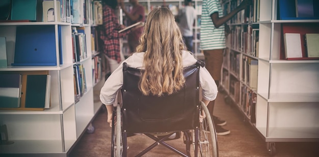 Behindertes Mädchen im Rollstuhl in der Bibliothek