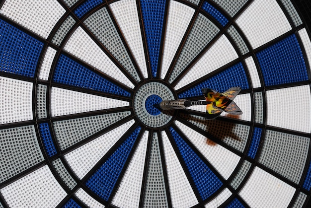 Bei einem Dartspiel trifft ein Pfeil ins Schwarze