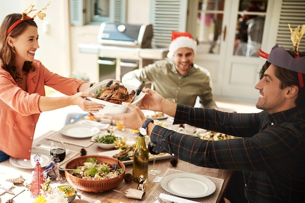 Bei Weihnachten dreht sich alles ums Teilen. Zugeschnittene Aufnahme von Menschen, die gemeinsam das Weihnachtsessen genießen