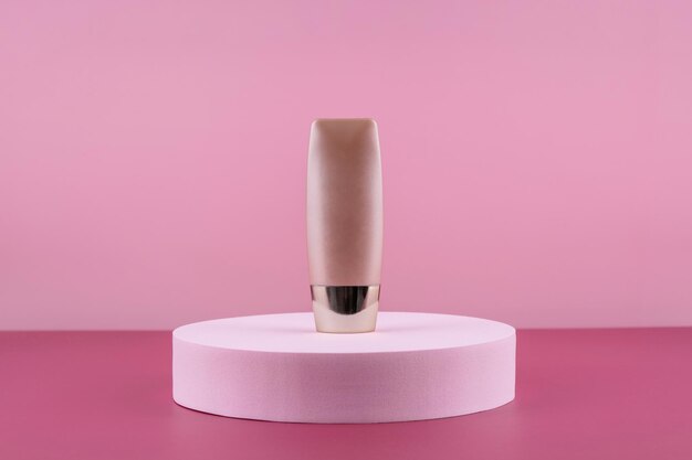 Foto beige concealer-basis-kosmetik-produkt-mockup auf rosa hintergrund kosmetik-flüssigkeits-foundation nude-cream-flaschen-mokup auf rundem podiums-piedestal hautpflege-beauty-primer-bb-korrektor