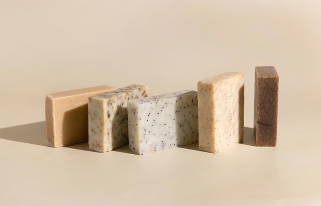 Beige natural de ervas e barras de sabão marrom feitas à mão em beige claro perto de sombras duras
