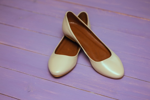 Beige Schuhe auf lila Hintergrund