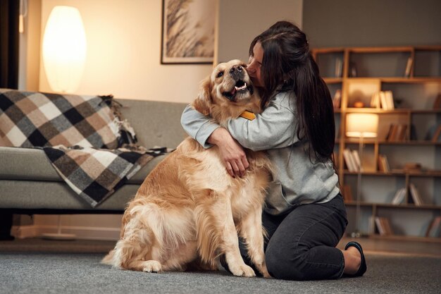 Foto beijando o cachorro mulher está com golden retriever em casa