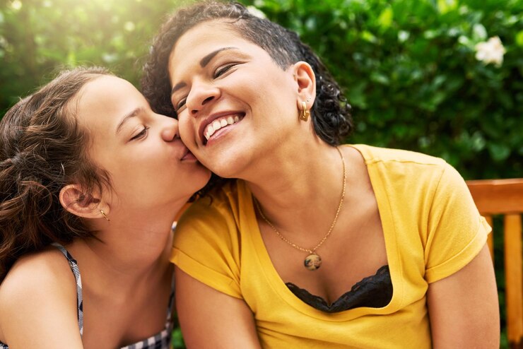 Foto beijos para a mãe foto recortada de uma adorável garotinha beijando sua mãe na bochecha enquanto estava no parque